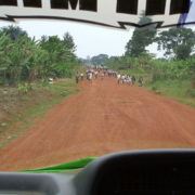 red dirt road full of school children