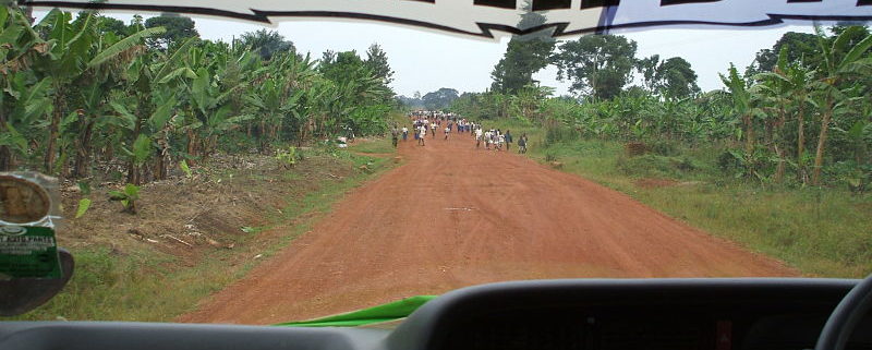 red dirt road full of school children