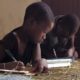 Tanzanian children doing homework on the floor