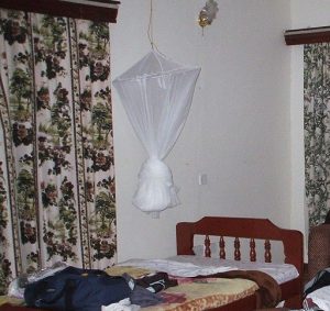 mosquito net hanging above a bed, tied up because not in use