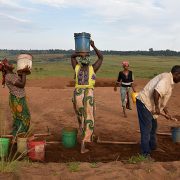 village women moving dirt on soccer field