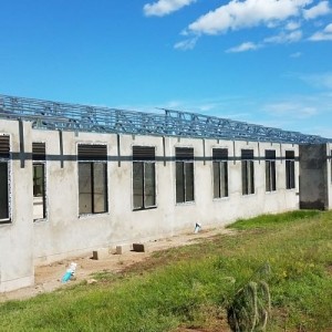 long concrete building with windows and steel trusses
