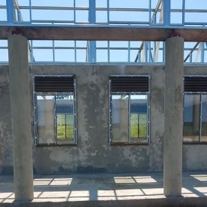 school corridor with columns, windows, steel trusses visible