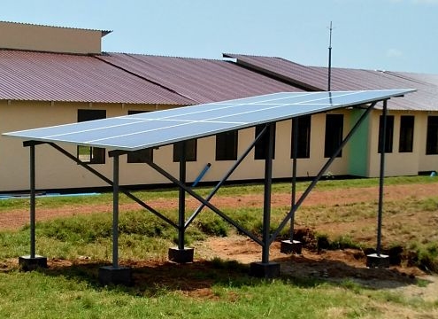 solar panels on stucture with school building behind