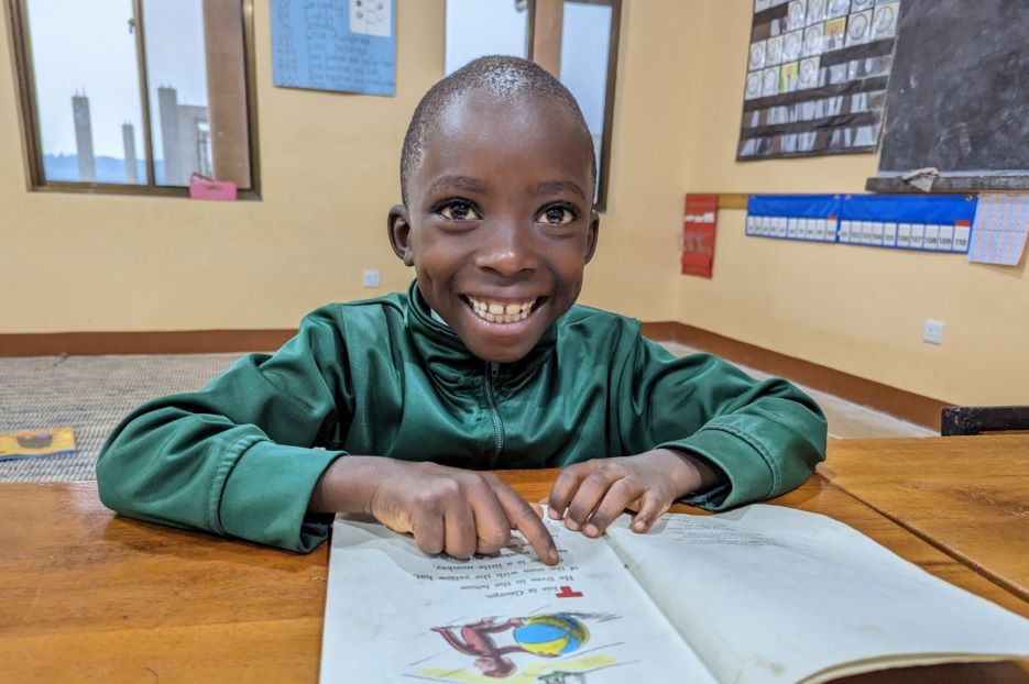 boy reading with big smile