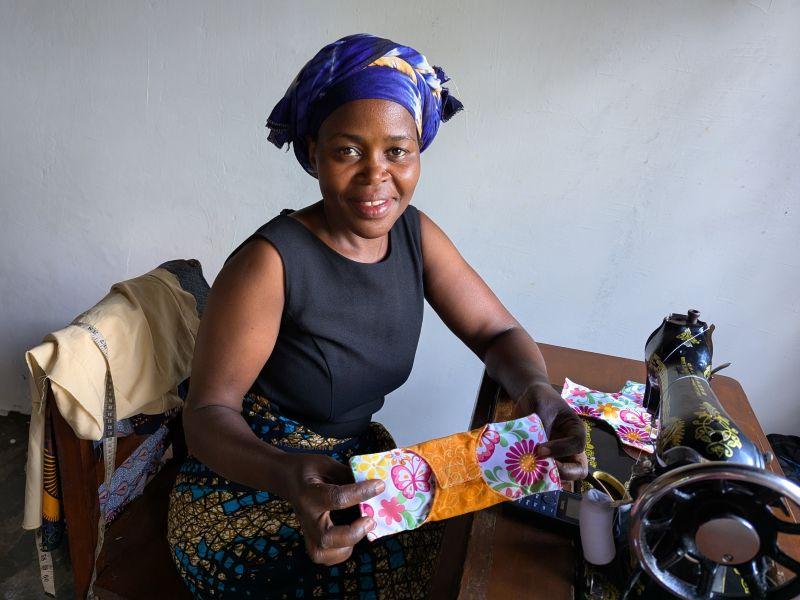 Woman at sewing machine holding colorful cloth pad