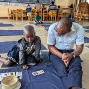 Teacher on floor with one student and cards with pictures