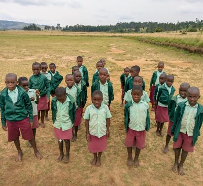 children wearing standing uniforms in rows outside