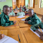 group of students at desks with pencils and notebooks