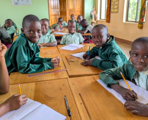 group of students at desks with pencils and notebooks